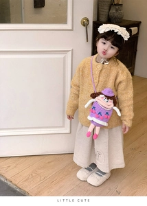 Detail view of purple hand-knitted girl doll crossbody bag with elegant pearl decoration