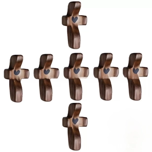 Detailed view of dark walnut wooden crosses with heart centers arranged in a set of seven