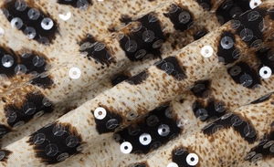 Macro view of leopard print fabric with shimmering sequins and soft draped texture