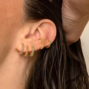 Five colorful pavé-set huggie earrings with sparkling cubic zirconia shown on model's ear