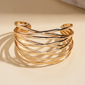 Detailansicht des breiten mehrlagigen goldenen Armreifs mit poliertem Metallic-Finish