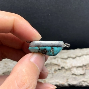 Detailed view of turquoise gemstone connector with antique silver double loops for jewelry