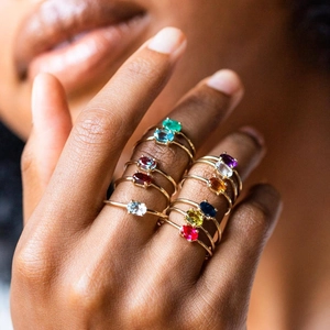 Gold-plated brass rings with colorful oval-shaped gemstones on female hands