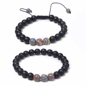 Détail de perles en pierre noire mate de 8mm et perles à rayures colorées sur bracelets