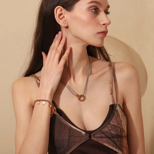 Close-up of gold and silver double-layered necklaces and bracelets with star and heart charms