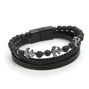 Detailed macro view of layered black lava stone beads and woven leather strap with anchor