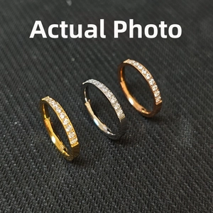 Detailed view of three stackable titanium rings in gold, silver, and rose gold with CZ stones