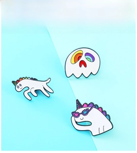 Detail view of colorful enamel pins featuring creative ghost and dinosaur badge designs