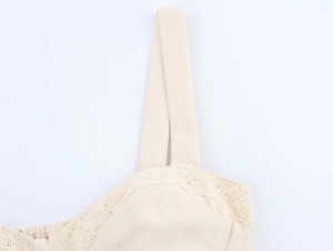 Detailed view of beige lace trim and wide shoulder strap on a cropped camisole top