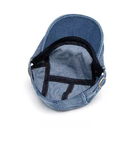 Detailed interior view showing black stitched edges of blue denim flat cap