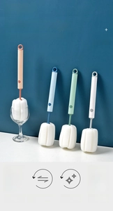 Detail of four colorful sponge bottle brushes with long handles and hanging holes