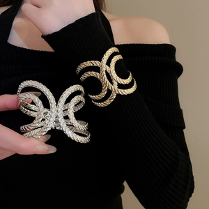 Close-up of golden and silver metal hair claws with detailed spiral rope texture