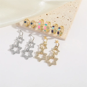 Elegant geometric star drop earrings and evil eye hoops on luxury silk backdrop