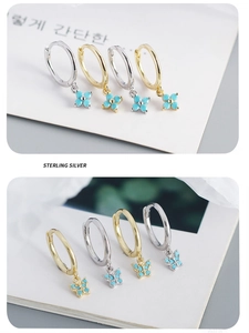 Detail of 925 sterling silver butterfly and flower earrings with blue turquoise inlay