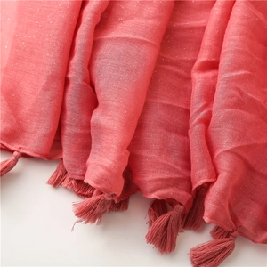 Detailed close-up of pink cotton linen scarf featuring sparkling glitter and fringe tassels