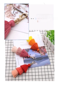 Detailed close-up of triple-layered gradient tassel keychain with golden lobster clasp