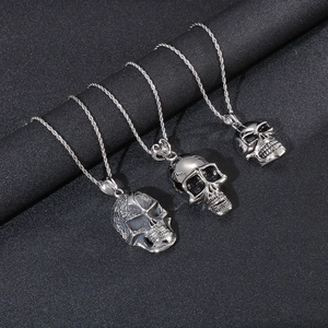 Three silver skull necklaces with punk design on dark background for men's fashion
