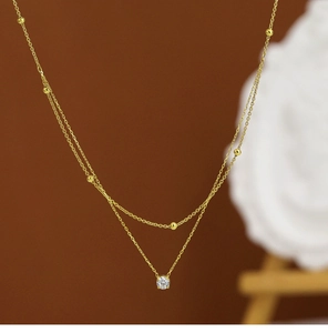 Macro view of double-layer 18K gold plated necklace with central cubic zirconia stone