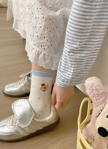Close-up of white cotton socks featuring a cute cartoon bear pattern on the ankle