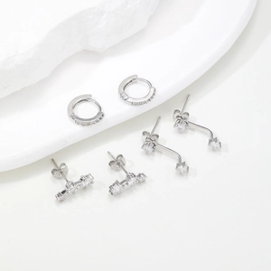 Detailed macro view of silver cubic zirconia earrings set with a minimalist stone background