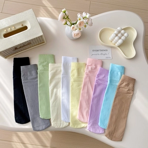 Colorful velvet mid-calf socks for women in various macaron colors on a white table