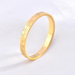 Detail of slim 18k gold plated titanium ring featuring engraved sunburst patterns