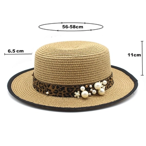 Detail of straw boater hat with leopard print ribbon, pearls, and size measurements