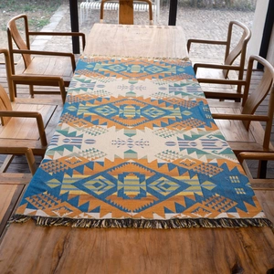 Bohemian geometric picnic mat and outdoor camping blanket with tassels on a wooden table