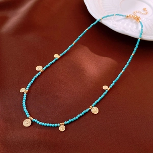Detailed macro view of turquoise beaded necklace with vintage gold metal pendants