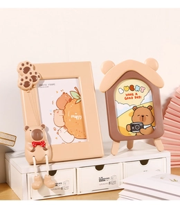 Detail von zwei süßen Cartoon-Fotorahmen mit Teddybären auf einem weißen Schrank