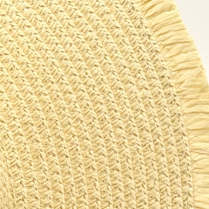 Macro detail of natural beige straw weaving with handcrafted fringe edge on a sun hat
