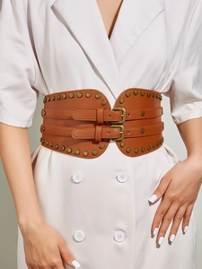 Close-up of a brown faux leather corset belt with brass buckles and rivet details