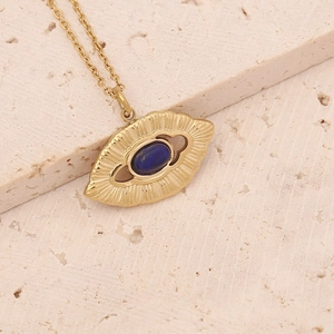Detail of a vintage gold necklace featuring an oval blue natural stone on a beige stone base