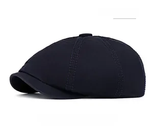 Detailed view of navy blue cotton newsboy cap showing top button and twill fabric texture