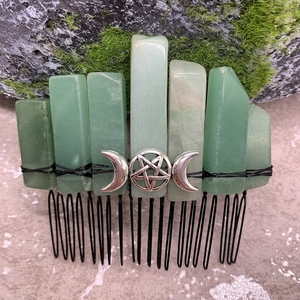 Macro detail of raw green crystal hair comb with silver moon and star metal ornaments