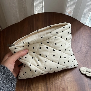 Quilted corduroy makeup bag with black hearts and a secure metal zipper detail