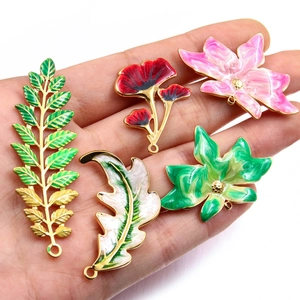 Close-up of colorful enamel flower and leaf charms with gold plating for jewelry making