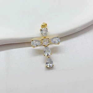Gold plated cross pendant with teardrop zircons on white ceramic plate, luxury DIY accessory