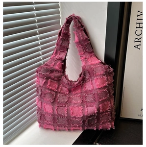 Detail of fuchsia plaid tote bag showing fringe texture and premium woven fabric detail