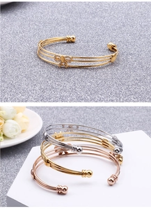 Vue détaillée du bracelet triple rang en acier inoxydable avec des papillons en cristal