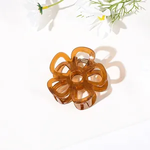 Detail of a brown translucent flower hair claw clip with golden metal spring