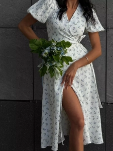 White cotton wrap dress with blue floral print featuring puff sleeves and a V-neckline