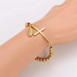 Gold stainless steel beaded bracelet featuring a cross and Virgin Mary oval pendant charm