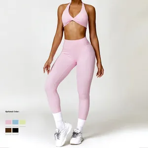 Pink two-piece yoga set featuring twist front sports bra and high-waisted leggings