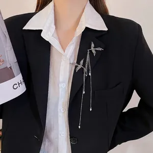 Elegant silver bird brooch with pearl tassels pinned on a professional black blazer