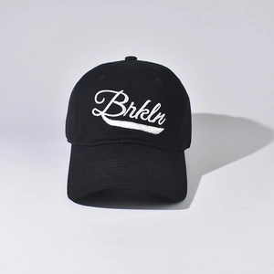 Close-up of white Brkln embroidery on black cotton baseball cap with curved brim
