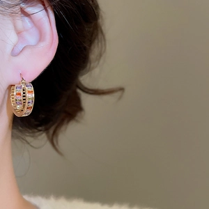 Close-up of 18K gold plated C-shaped hoop earrings with colorful zircon stones on model