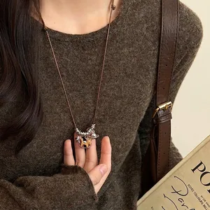 Tiger eye horse pendant pearl necklace with brown leather cord on knit sweater