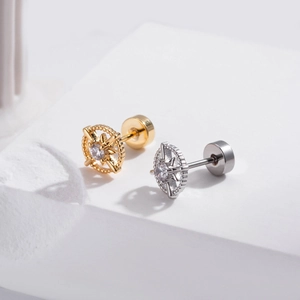 Gros plan de boucles d'oreilles dorées et argentées avec zircons sur un support blanc