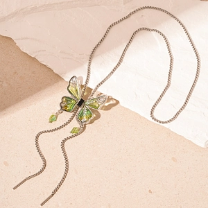 Detail of vintage butterfly tassel necklace with green glass wings and crystal accents